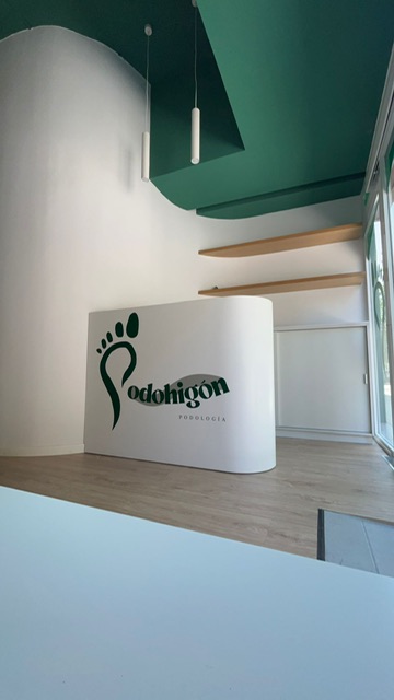 Mostrador de recepción de Podohigón con el logo de la huella verde